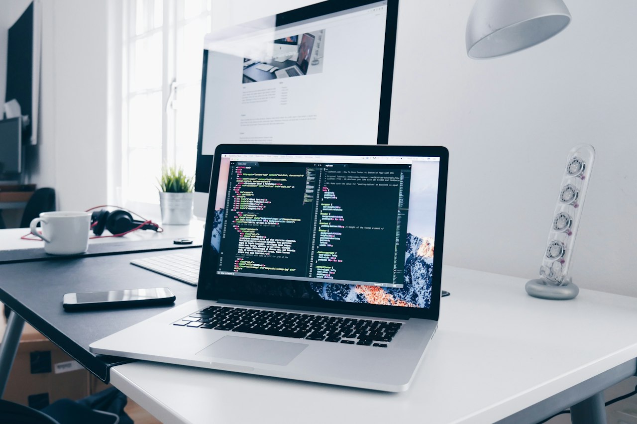 Developer writing code across two monitors